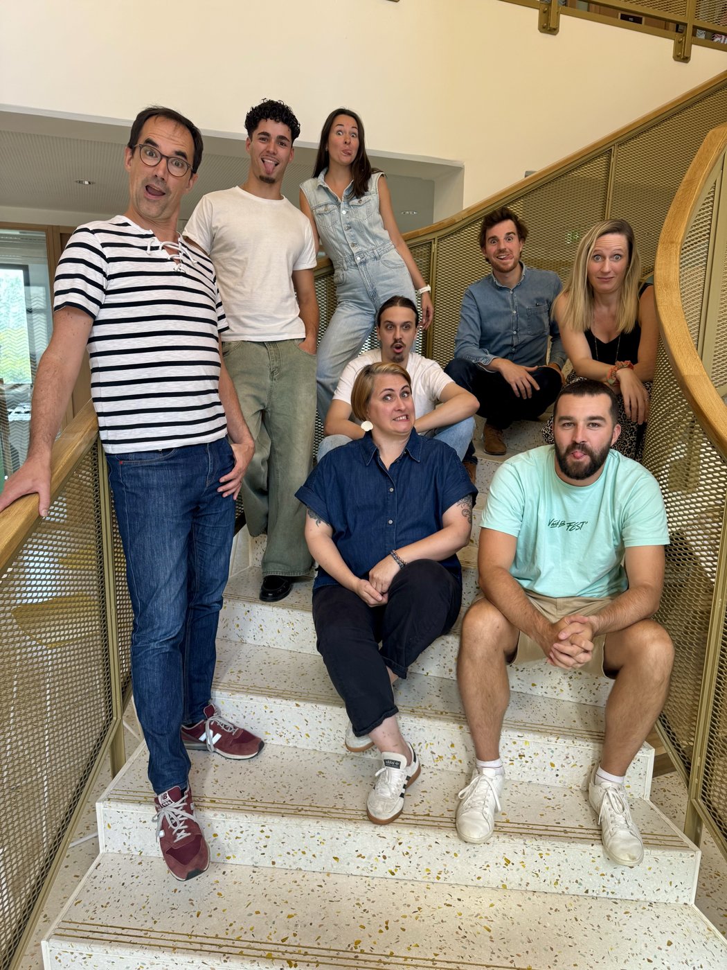 L’équipe Olo Suite réunie dans un escalier, chacun fait une grimace à l’objectif